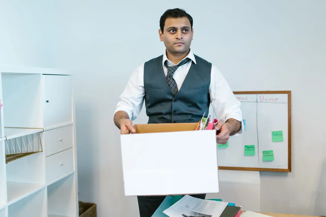 Beschriftete Umzugskisten und Bürostühle in einem Großraumbüro